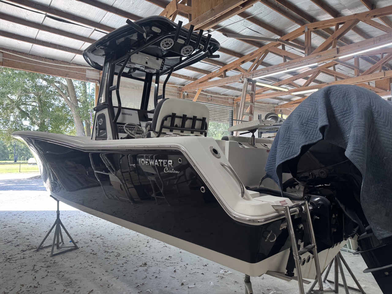 Black Tidewater Custom boat inside workshop after professional gelcoat restoration and color matching by Outboard Service Express